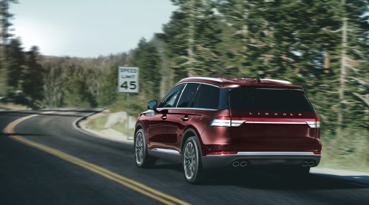 A 2024 Lincoln Aviator® SUV is being driven on a winding mountain road | Rydell Lincoln in Independence IA
