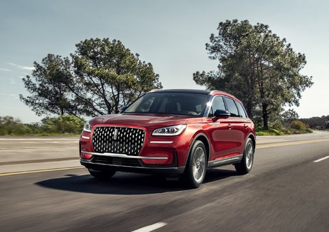 A 2024 Lincoln Corsair® SUV is shown being driven on a country road. | Rydell Lincoln in Independence IA